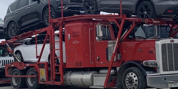 Car hauling truck delivering vehicles to dealerships